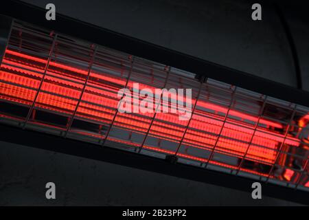 un chauffage infrarouge allumé sur un mur de maison Banque D'Images