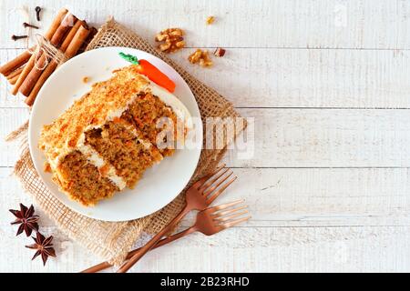Tranche de gâteau de carotte maison avec glaçage au fromage à la crème. Vue sur un fond rustique en bois blanc. Banque D'Images