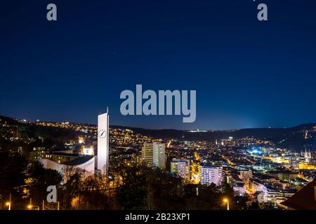 Allemagne, Belle vue aérienne au-dessus des maisons de la ville de stuttgart, église et horizon dans le bassin, illuminée de nuit à la lumière de la pleine lune avec ciel étoilé Banque D'Images