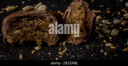 Chocolats belges au caramel maison sur fond sombre Banque D'Images