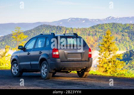 4x4 sur le bord d'une montagne. belle vue sur la vallée lointaine pleine de brouillard. ridge au loin. fantastique paysage printanier le matin Banque D'Images