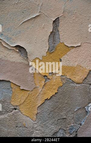 Détail abstrait de peinture écaillée et de plâtre fissuré sur une surface murale altérée Banque D'Images