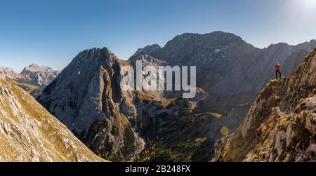 Mountaineer avec casque d'escalade se tient sur un affleurement rocheux, sentier de randonnée à l'Ehrwalder Sonnenspitze, Ehrwald, Mieminger Kette, Tyrol, Autriche Banque D'Images