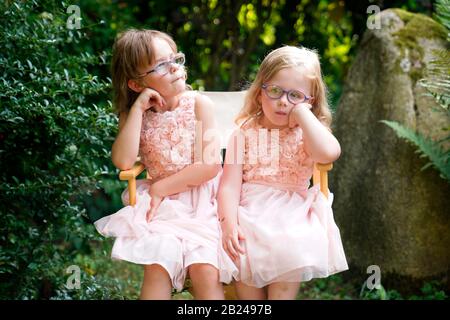 Portrait de deux sœurs assises ensemble sur une chaise de jardin (6 ans, 3 ans), République tchèque Banque D'Images