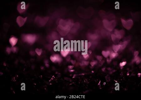 Fond sombre abstrait avec bokeh rose flou coeur forme Banque D'Images