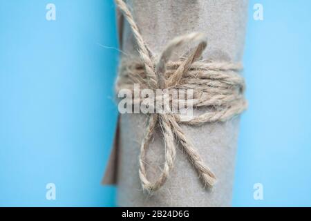 emballage rouleau dans du papier artisanal sur fond bleu. Banque D'Images