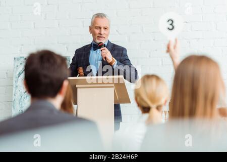 objectif sélectif de la vente aux enchères parler avec le microphone et regarder l'acheteur pendant la vente aux enchères Banque D'Images