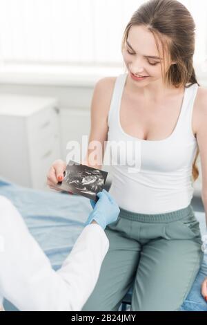 médecin donnant une échographie à une jeune femme enceinte heureuse en clinique Banque D'Images