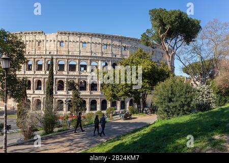 Les touristes marchent dans le parc donnant sur le Colisée de Rome Banque D'Images