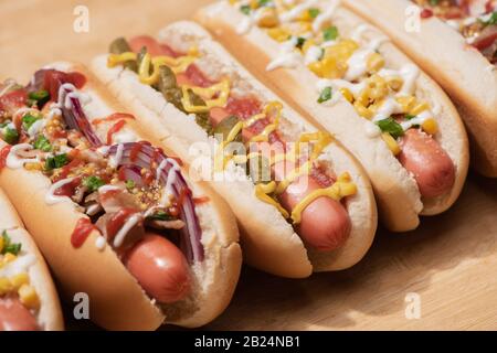 divers délicieux hot-dogs avec légumes et sauces sur table en bois Banque D'Images