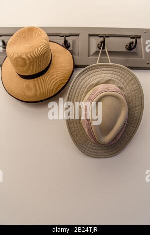 Photo verticale de deux chapeaux accrochés sur un rack sur un mur. Pas de gens Banque D'Images