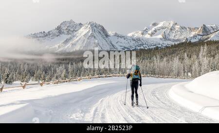 L'homme de ski de fond voyage le long d'un sentier à une chaîne de montagne Banque D'Images