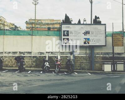 Sanremo, Italie - 22 novembre 2019: Motos garées cyclomoteurs près de Publicité OOH conseil pour les concerts à venir au Casino Sanremo Banque D'Images