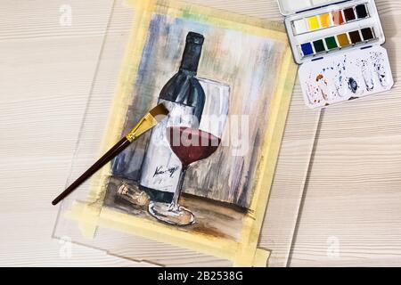 Dessin en aquarelle en cours. Vue sur le lieu de travail de l'art. Bouteille d'aquarelle en verre de vin rouge Banque D'Images