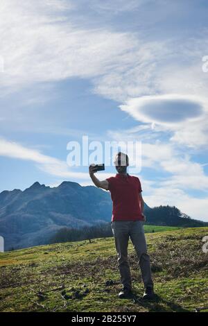 Un jeune homme touristique rendant selfie avec une vue sur la montagne dans les Pyrénées espagnoles, Pays basque Banque D'Images