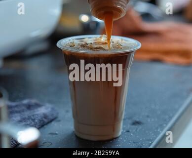 Sur le comptoir dans le café. Café en cours de fait. Il s'agit de macchiato caramel glacé. Des boissons fraîches en été vous permettent de vous rafraîchir et de vous rafraîchir. Banque D'Images