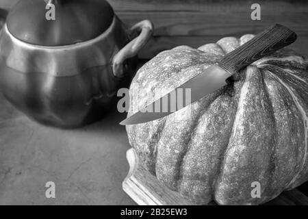 Une grande citrouille à côté d'un pot en céramique Banque D'Images