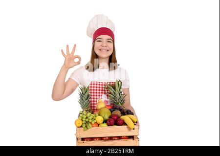 bonne cuisinière avec fruits et bon signe de main Banque D'Images