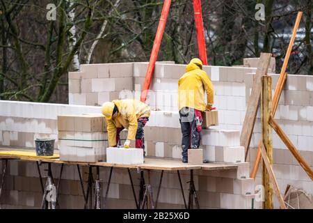 Site de construction, maison résidentielle est en construction, maçons au travail, ponction d'un mur, sur un échafaudage, haut, Banque D'Images