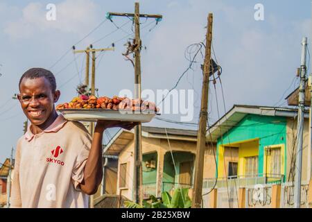 Un vendeur de noix de kola dans une rue de Lagos, au Nigeria. Banque D'Images