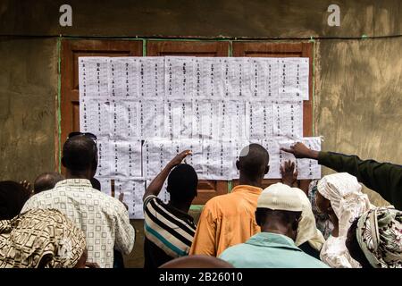 Les électeurs vérifient leur nom avant de voter dans un bureau de vote lors des élections de 2014 en poste de gouverneur dans l'État d'Osun, au Nigeria. Banque D'Images