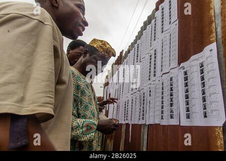 Les électeurs vérifient leur nom avant de voter dans un bureau de vote lors des élections de 2014 en poste de gouverneur dans l'État d'Osun, au Nigeria. Banque D'Images