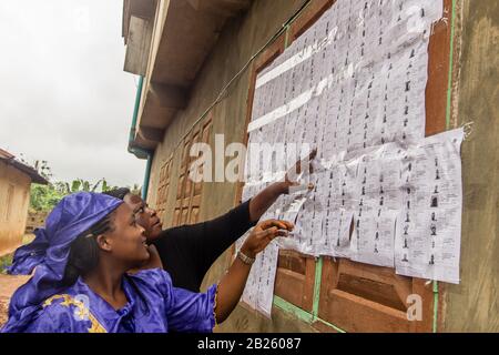 Les électeurs vérifient leur nom avant de voter dans un bureau de vote lors des élections de 2014 en poste de gouverneur dans l'État d'Osun, au Nigeria. Banque D'Images