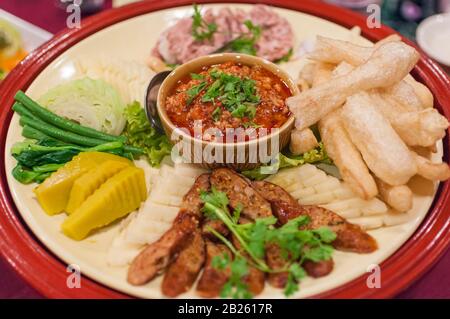 Assiette avec plat alimentaire traditionnel du nord de la Thaïlande Nam Prik, Légumes cuits à la vapeur et saucisse Sai Oua à Chiang Mai Banque D'Images