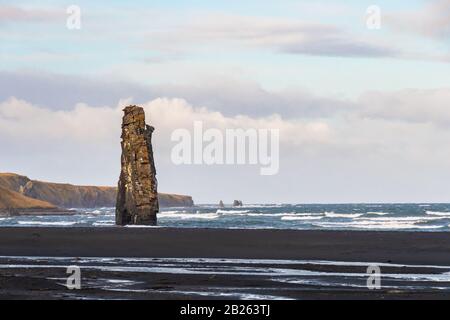 Formation de roches Hvitserkur en formation de basalte d'Islande debout devant une plage de sable noir et de hautes falaises Banque D'Images