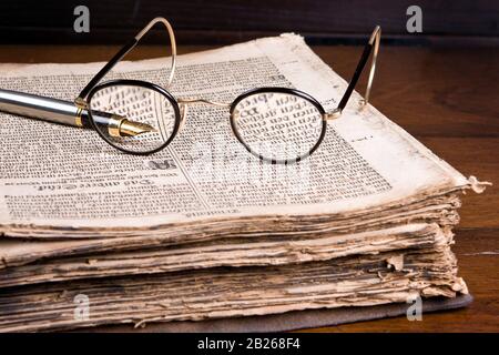 Lunettes et plume sur un livre ancien de plus de 300 ans (1691 pour être précis). La langue est l'ancienne-germanique. Banque D'Images