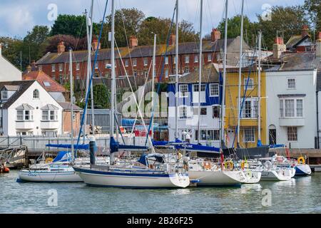 Yachts amarrés et bateaux dans le port de Weymouth avec maisons colorées sur la côte jurassique de Dorset, Sud-Ouest, Royaume-Uni Banque D'Images