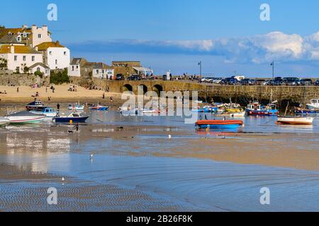 Plage du port au port de St Ives avec maisons et jetée de Smeatons au loin, les gens sur la plage et les bateaux de pêche amarrés, Cornwall, S West Banque D'Images