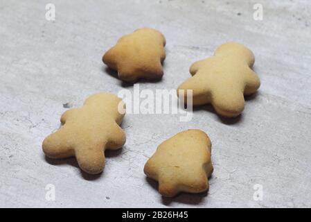 Cookies sous forme d'un homme de pain d'épices et d'un arbre de Noël sur fond gris texturé. Banque D'Images