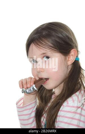 Jeune fille mangeant un biscuit au chocolat Banque D'Images