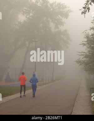 Un coureur en bonne santé, homme et femme, s'entraîner sur la route au bord de la rivière. Jogging hommes et femmes modèle de forme physique s'entraîner pour le marathon sur la forêt Banque D'Images