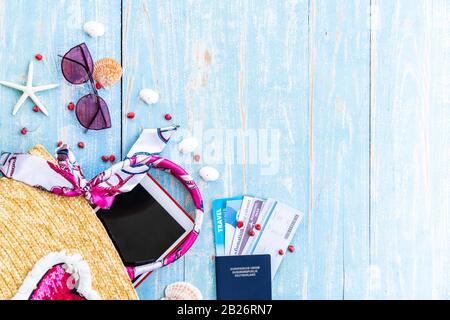 Fond bleu d'été avec une tablette passeport de sable de étoiles de mer sur fond bleu de table en bois avec espace de copie Banque D'Images