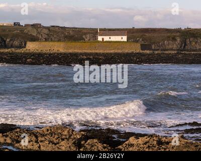 En face de l'église de St Cwyfan une église médiévale classée de Grade II à Llangadwala Anglesey North Wales située sur la petite île marémotrice de Cribinau Banque D'Images