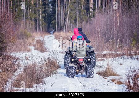 Famille sur l'VTT Quad vélos sur la route d'hiver. Banque D'Images