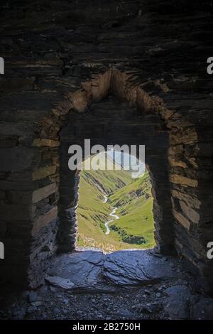 Vue sur la vallée par la fenêtre de la forteresse. Lieu - région de Tusheti en Géorgie. Tour Dartlo. Banque D'Images