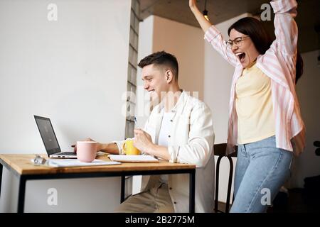 femme émotionnelle dans les lunettes debout avec des bras relevés, profitant de la victoire de l'équipe préférée, le sport, le hockey, le foot, les fans de tennis. nous l'avons fait. g Banque D'Images