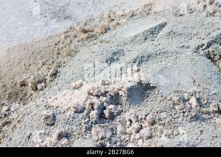 Mélange sec de ciment Portland et de sable de mer partiellement mélangé à une journée chaude et vive Banque D'Images