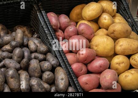 Pommes de Terre bleues, rouges et jaunes disponibles sur une étagère d'épicerie Banque D'Images