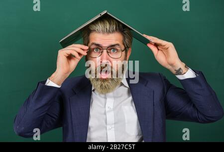 Beaucoup d'informations. Homeschooling. Folie en ligne. Fournir des informations à jour précises. L'enseignant tient un ordinateur portable surfer sur Internet. Homme barbu portable sur la tête. Informations intéressantes. Sauvetage scolaire. Banque D'Images