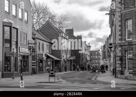 Une image de la jonction de Lendal et de Museum Street à York. Les clients marchent dans la rue et un ciel nuageux est au-dessus. Banque D'Images