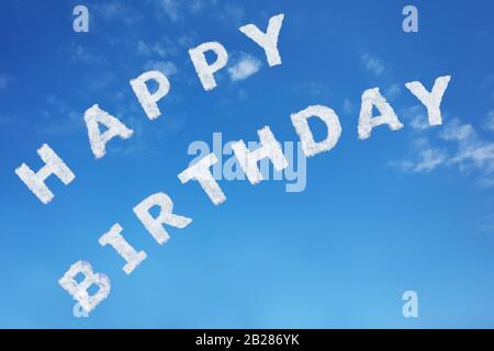 Joyeux anniversaire signe texte en lettres nuages sur ciel bleu clair de jour Banque D'Images