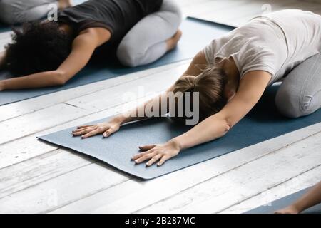 Les femmes qui pratiquent la Pose d'enfant réduisent la fatigue après l'entraînement de près Banque D'Images
