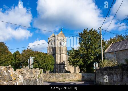 La tour de l'horloge de l'église St Nicolas dans le village de Winsley dans le Wiltshire contre un ciel bleu avec des nuages blancs moelleux Banque D'Images