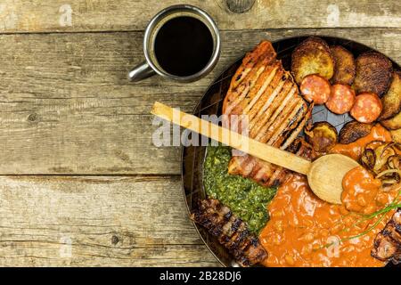 Hachez le porc sur la poêle en acier avec les haricots et les épinards. Viande grillée dans une poêle à frire. Nourriture calorique. Repas gras. Pommes de terre frites avec viande dans une poêle Banque D'Images