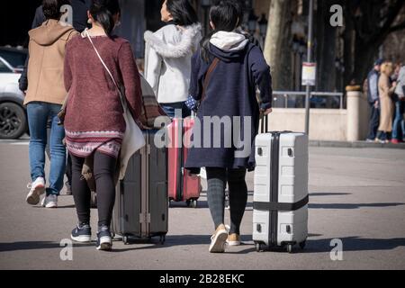 Les touristes tenant leurs valises se rendent à l'arrêt AeroBus pour l'aéroport Prat de Barcelone. Le Ministère de Salut rapporte de nouveaux cas de coronavirus dans la communauté autonome de Catalogne (Espagne) augmentant le nombre à douze affectés. Le nombre de touristes à Barcelone présente un profil bas. Les masques hygiéniques commencent à être un élément plus fréquent parmi la population. Banque D'Images