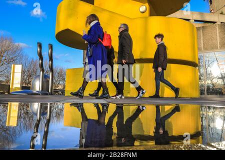 Londres, Royaume-Uni. 1 mars 2020. Les visiteurs du Southbank Center de Londres se reflètent dans les flaques de pluie lorsqu'ils franchissent l'un des célèbres escaliers d'architecture brutaliste jaune vif du centre. La journée à Londres a vu un beau soleil avec un ciel bleu, en contraste saisissant avec la pluie et la tempête du samedi. Crédit: Imagetraceur/Alay Live News Banque D'Images